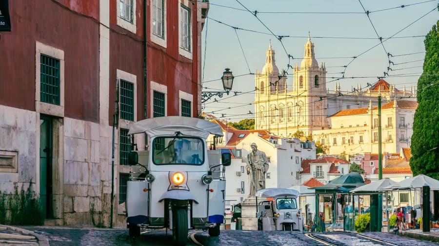 David's tuk-tuk on a cobbled Alfama street at golden hour